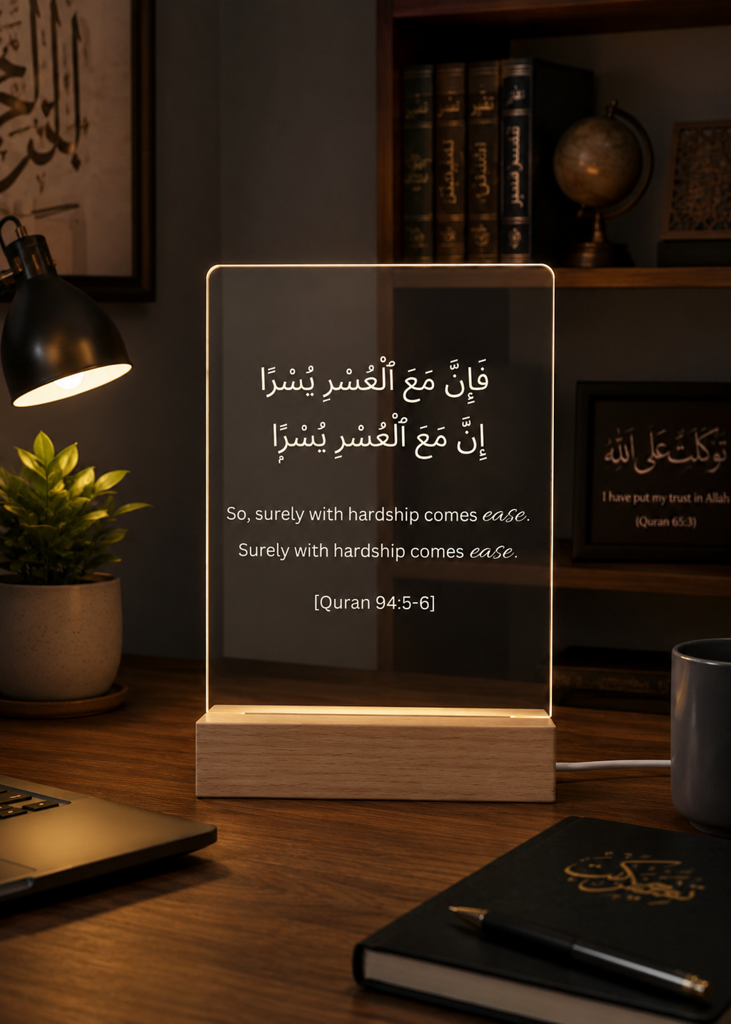 Acrylic panel with Quran verse on a desk with books and lamp in the background