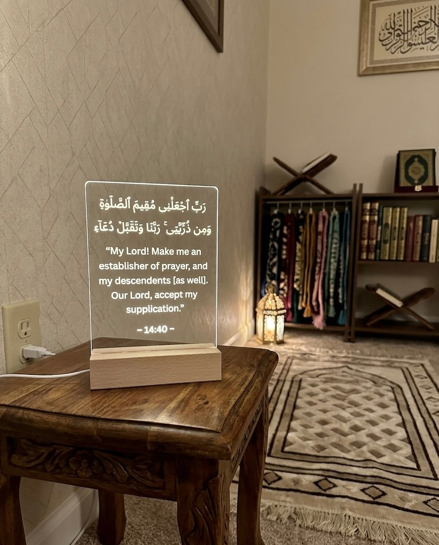 Acrylic plaque with Arabic text on a wooden table in a room with religious decor.