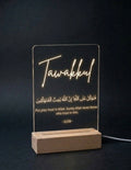 LED sign with 'Tawakkul' and Arabic text on a dark background