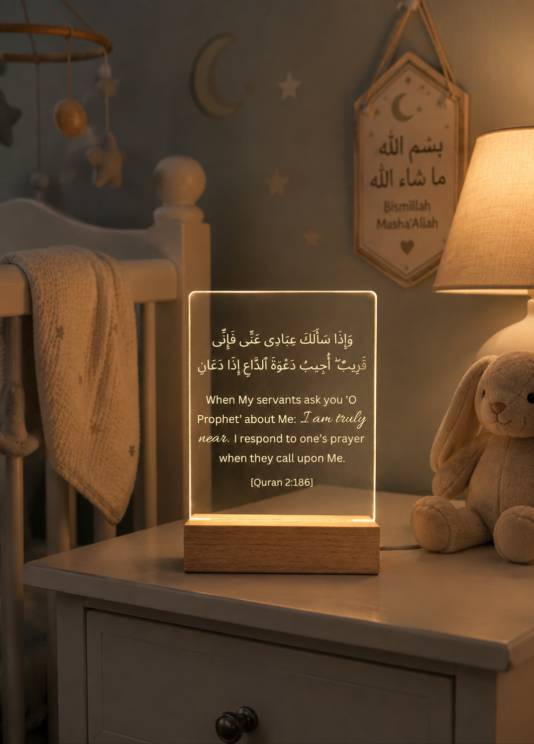 Decorative night light with Arabic text on a shelf in a nursery.