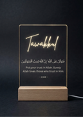 LED sign with 'Tawakkul' and Arabic text on a dark background